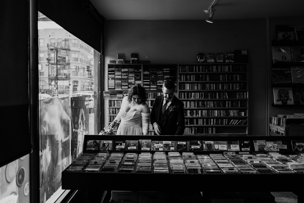 Chicago bride and groom sort through records at Reckless Records in Wicker Park on their winter wedding day
