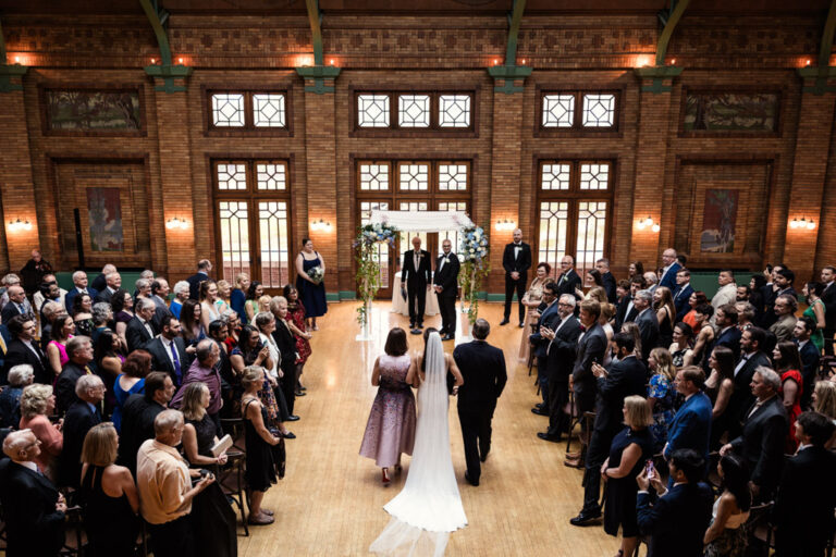Bride walks down aisle with parents at Cafe Brauer wedding ceremony in Great Hall