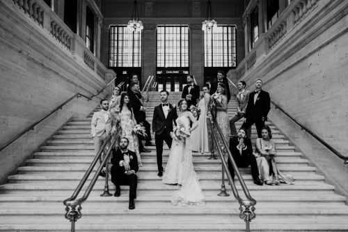Creative photo of wedding party standing on steps at Union Station in Chicago before spring wedding at The Arbory
