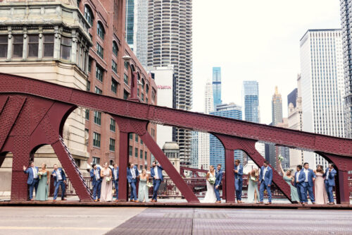 Fun photo of Chicago wedding party on LaSalle Bridge overlooking river before summer wedding at Ovation