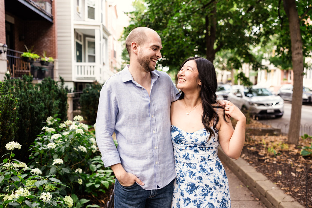 Couple walks along sidewalk during their summer Roscoe Village neighborhood engagement session in Chicago