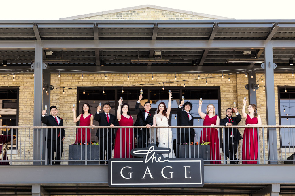 Wedding party cheers with champagne on balcony at The Gage Milwaukee wedding