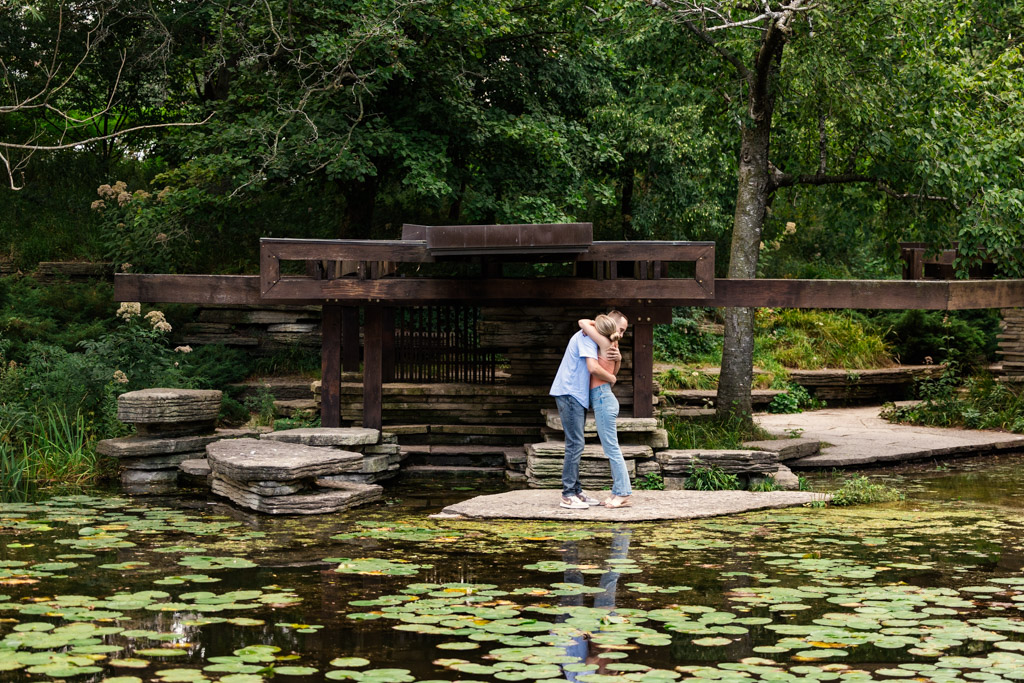Newly engaged couple embrace after surprise Alfred Caldwell Lily Pool proposal