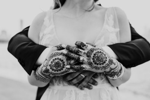 Detail photo of wedding rings on hands with henna outside Adler Planetarium wedding in Chicago