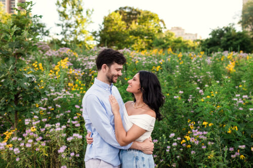 Happy couple stands in wildflower field during their summer Lincoln Park engagement session