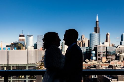 Silhouette photo of bride and groom in front of Chicago Skyline during their West Loop winter wedding