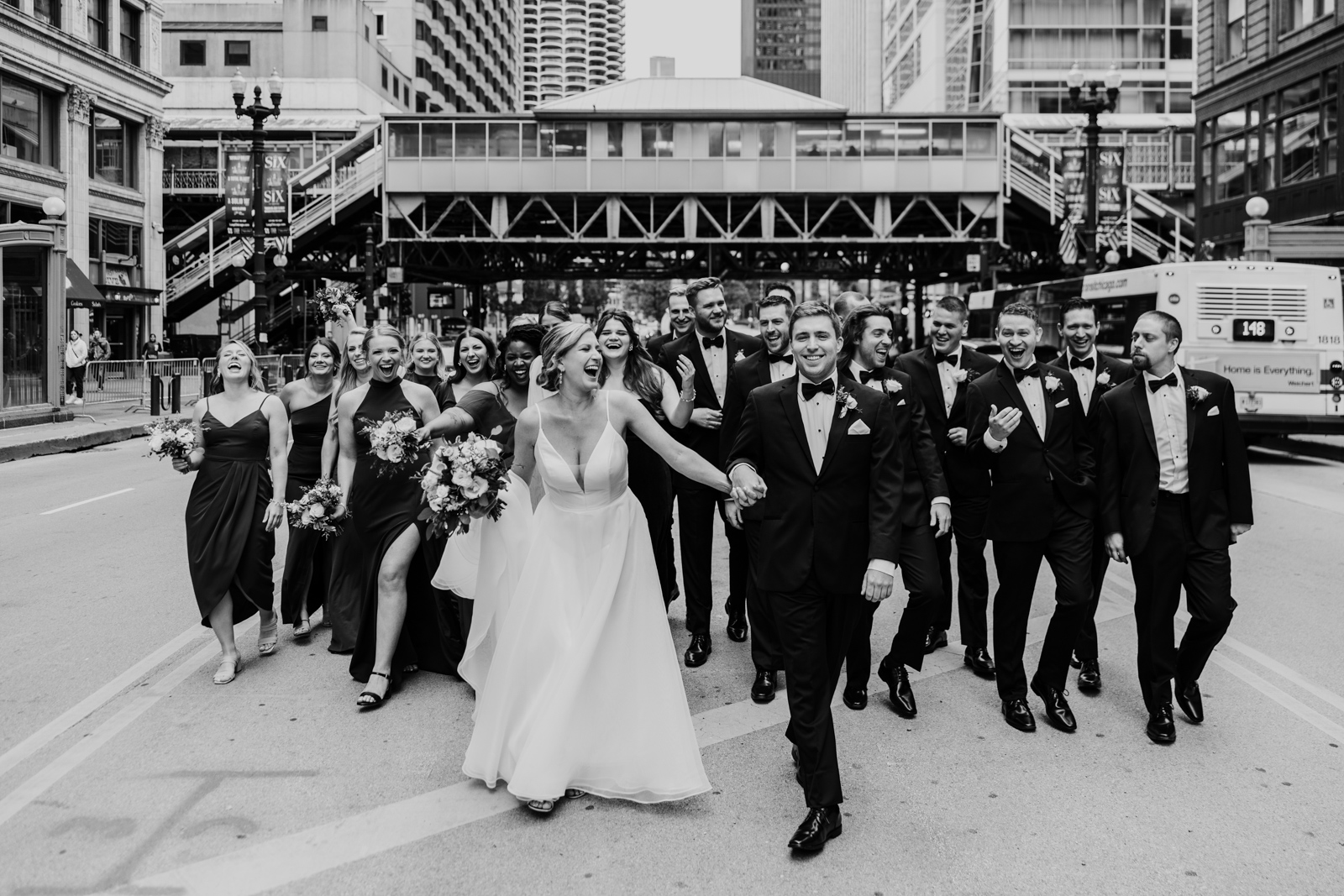 Fun photo of Chicago wedding party walking through State Street by Chicago wedding photographer Emma Mullins Photography