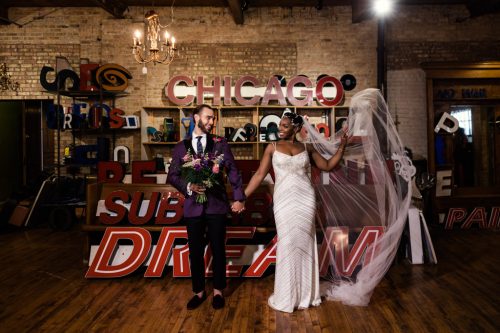 Bride and groom stand in front of marquee letters at Salvage One wedding venue in Chicago