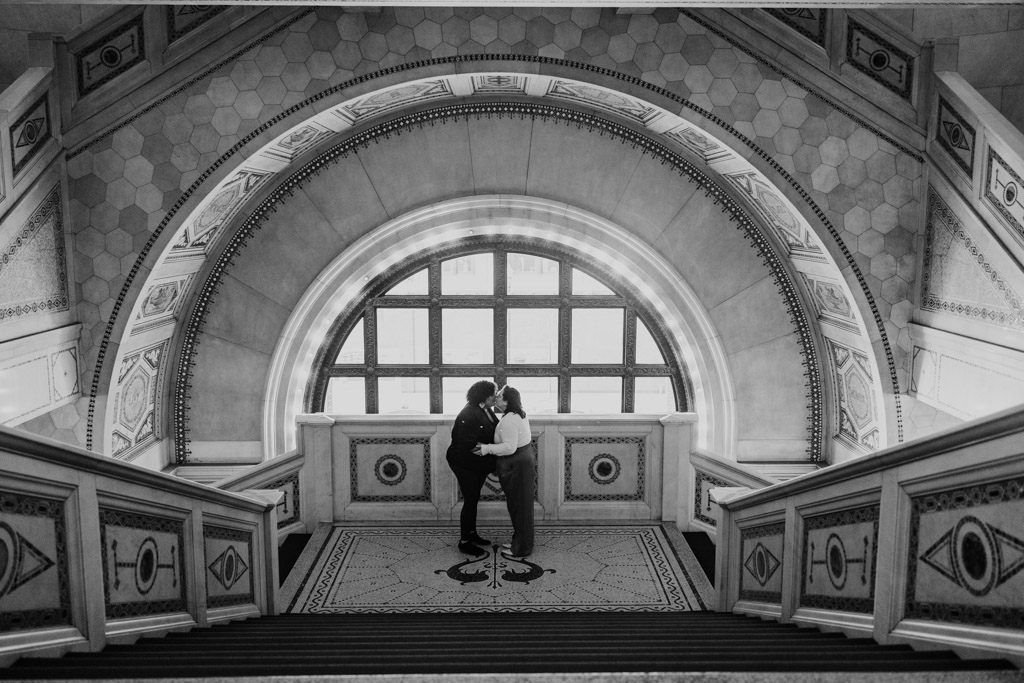 Romantic photo of couple kissing in mosaic window arch during Chicago Cultural Center engagement session