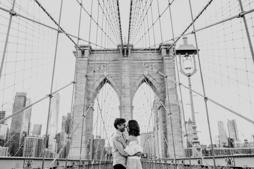 Creative black and white photo of couple on Brooklyn Bridge during spring NYC engagement session