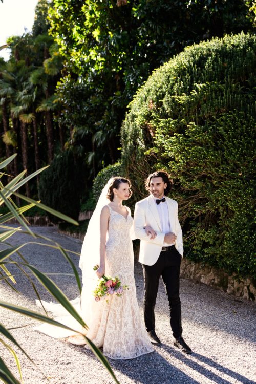 Bride and groom walk in sunshine outside Villa Pizzo wedding venue in Lake Como, Italy