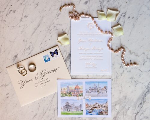 Custom wedding invitation suite and jewelry on marble table for Italy destination wedding at Villa Pizzo