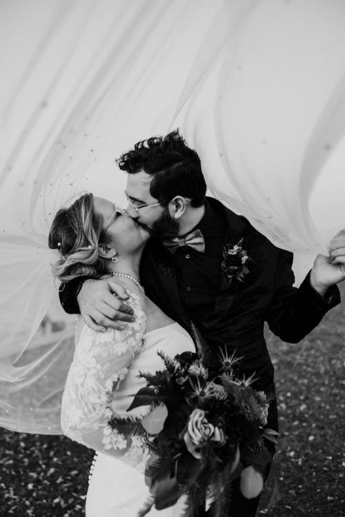 Romantic photo of bride and groom kissing under flowing veil before their space theme Adler Planetarium wedding