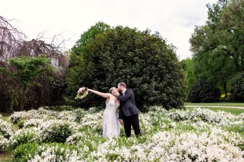 Just married bride and groom celebrate in spring flower beds after their Italy elopement in Parco Sempione