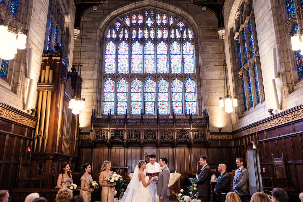 Wedding ceremony at gothic Bond Chapel on University of Chicago campus with stained glass window