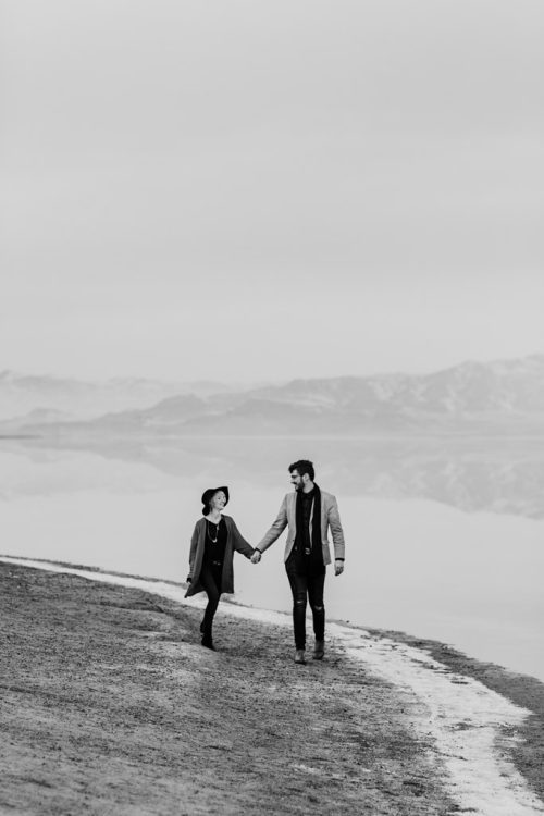 Bonneville Salt Flats engagement photo of couple running on salt with mountain view in background