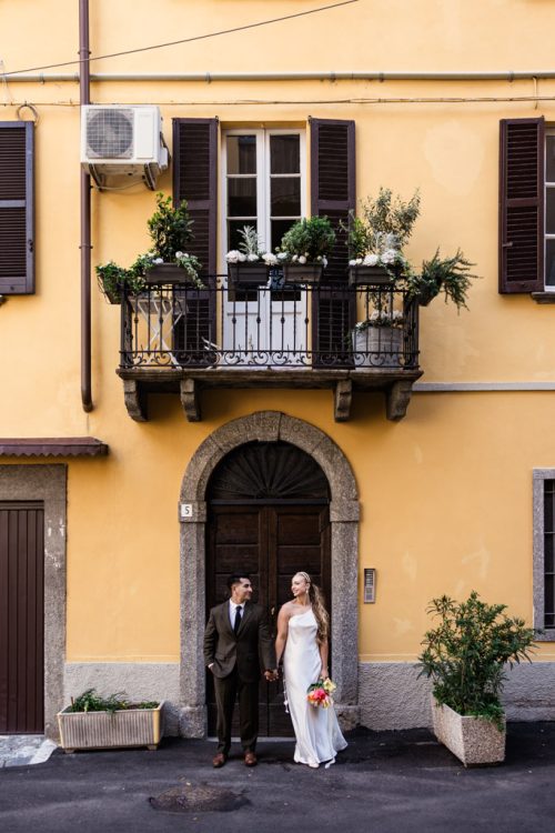 Bride and groom stand in Italian doorway smiling after their Lake Como, Italy elopement