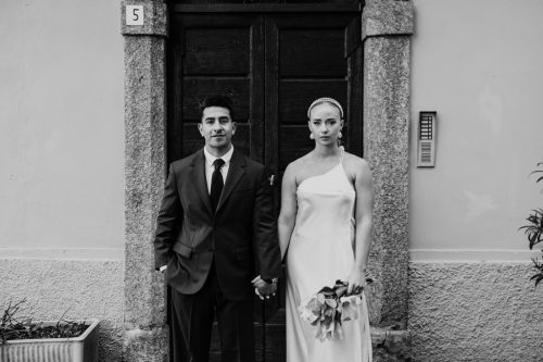 Creative photo of bride and groom standing in Italian doorway after their morning elopement in Lake Como