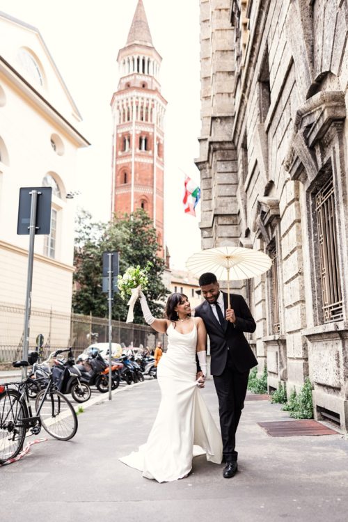 Just married bride and groom walk down streets of Milan after their Museo 900 wedding