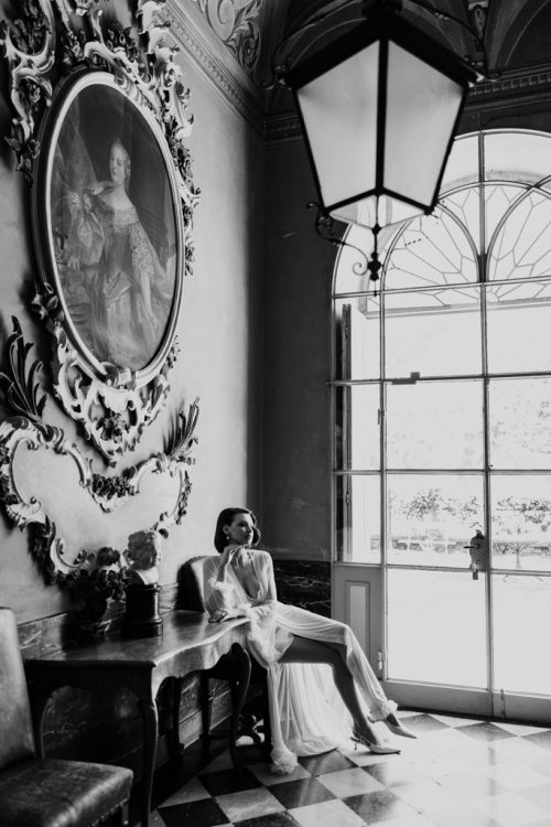 Black and white photo of bride sitting in chair at historic Villa Pizzo in Lake Como, Italy