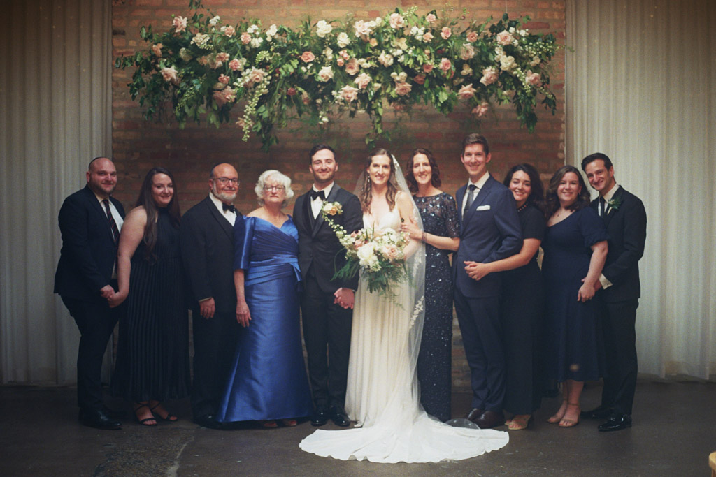 Family photo under floral installation at The Arbory Chicago wedding venue captured on film