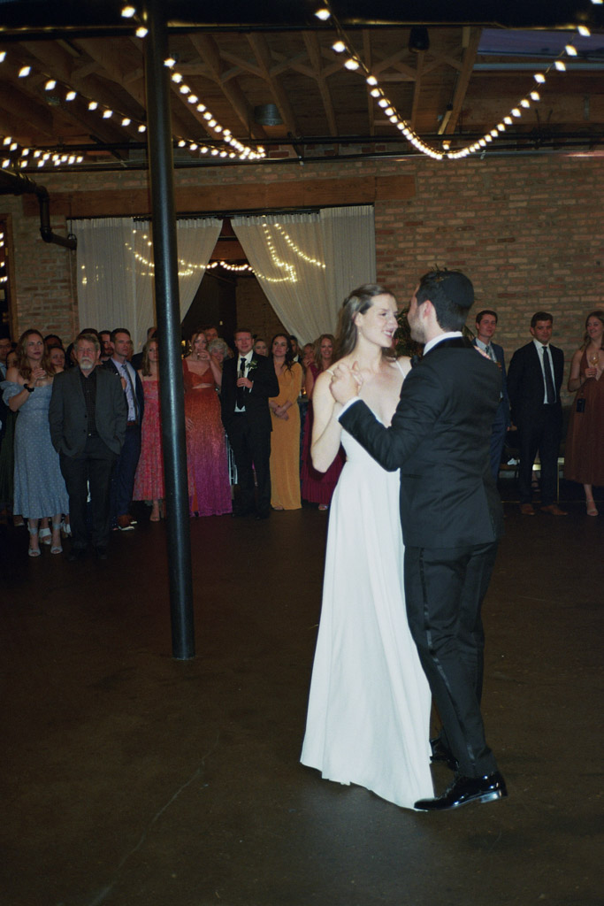 Film photo of bride and groom's first dance under string lights at The Arbory Chicago