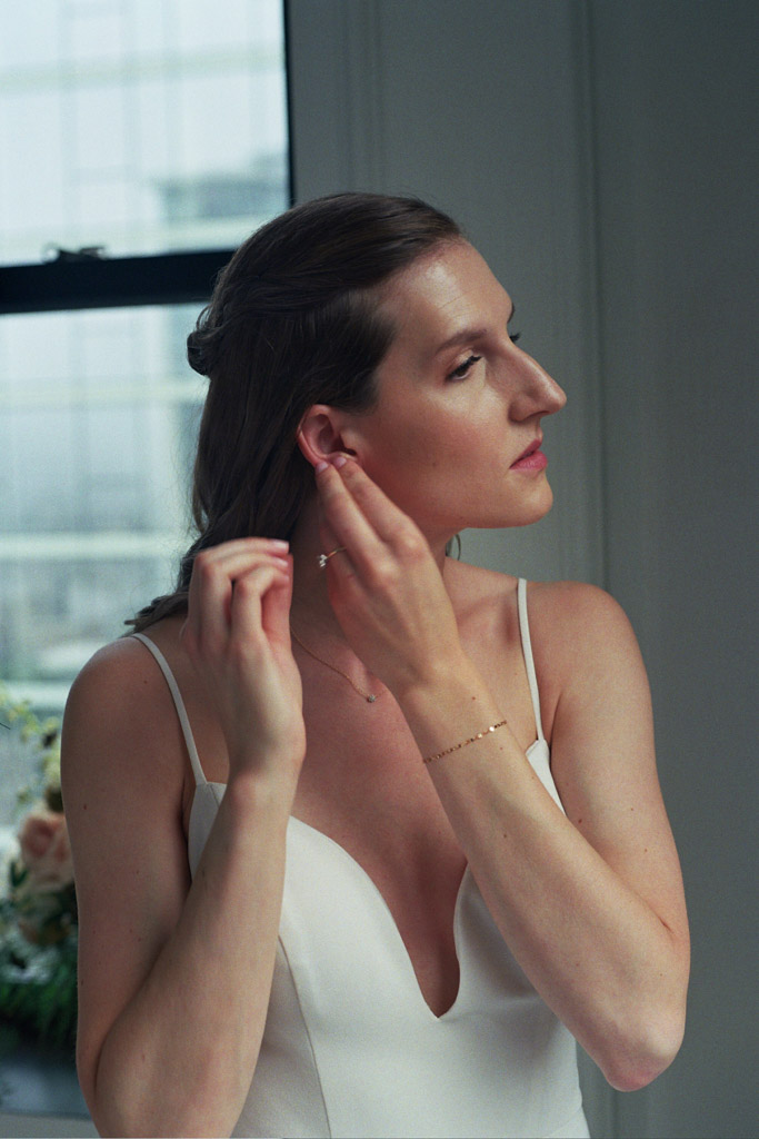 Bride puts on earrings in suite at Pendry Chicago hotel captured on film