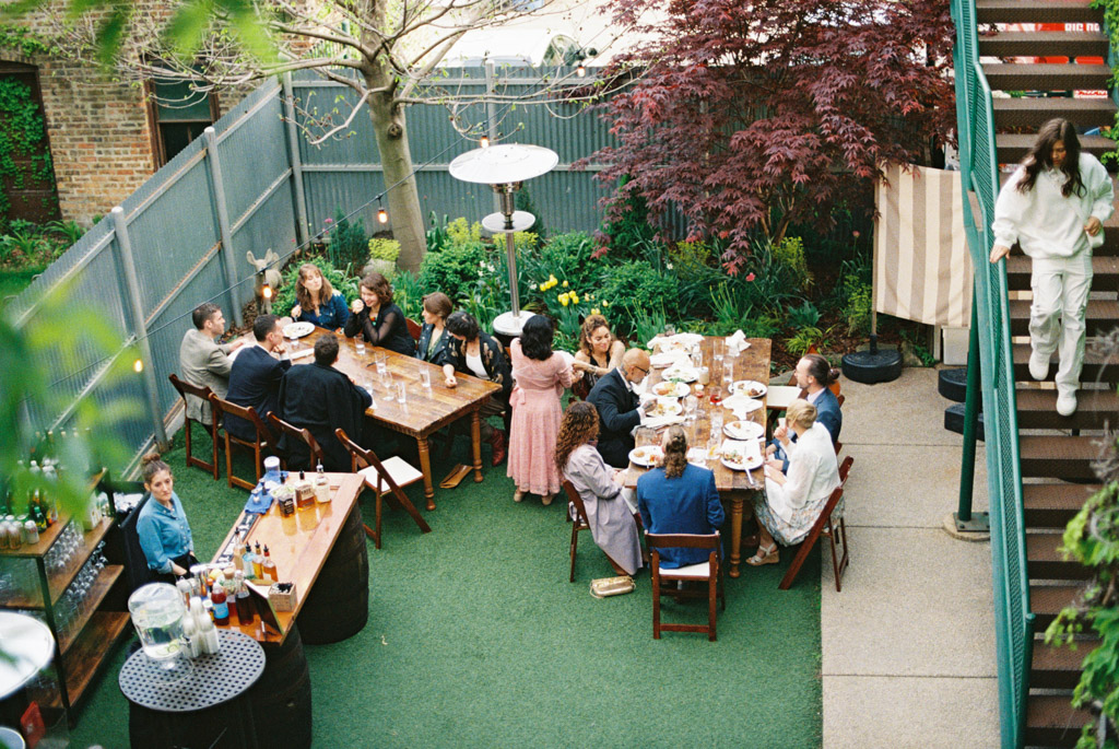 Guests mingle in backyard during dinner at spring Firehouse Chicago wedding reception