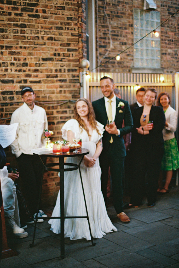 Blurry photo of couple smiling during speeches in outdoor garden at Firehouse Chicago wedding reception captured on film