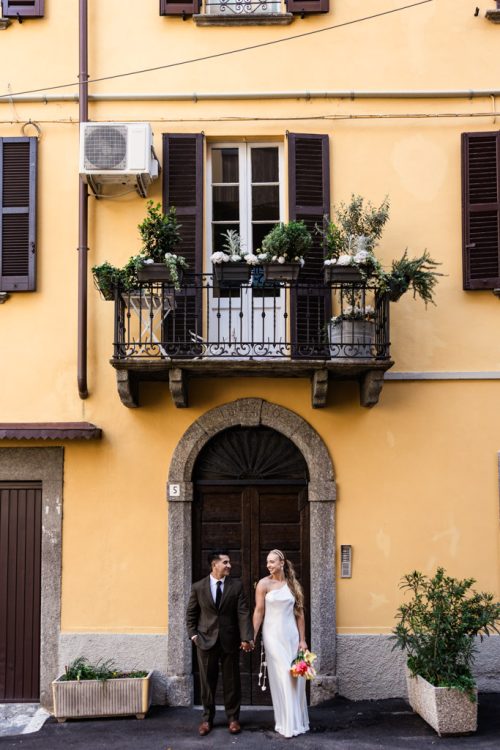 Bride and groom stand in Italian doorway smiling after their Lake Como, Italy elopement