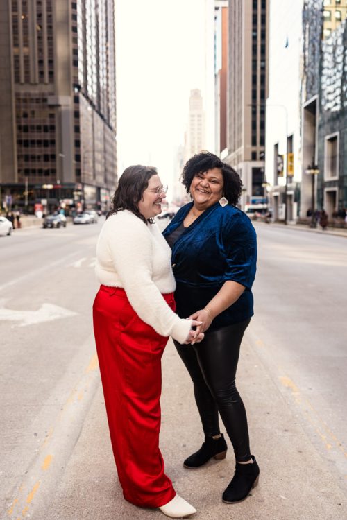 Candid photo of happy couple standing in median on Michigan Avenue in Chicago during downtown engagement session