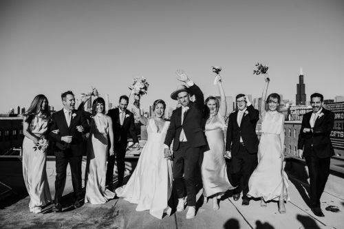 Fun photo of wedding party walking on rooftop of Chicago loft wedding venue The Hive on Hubbard