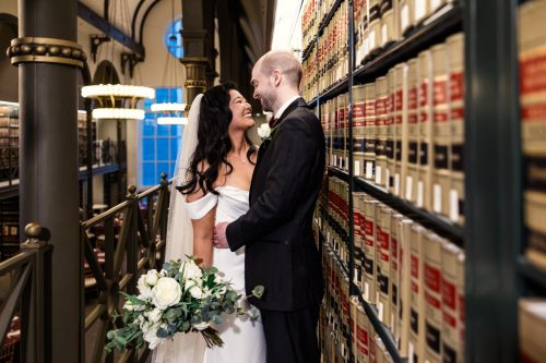 Romantic photo of bride and groom with stacks of books at downtown Chicago Library wedding at 190 S. LaSalle