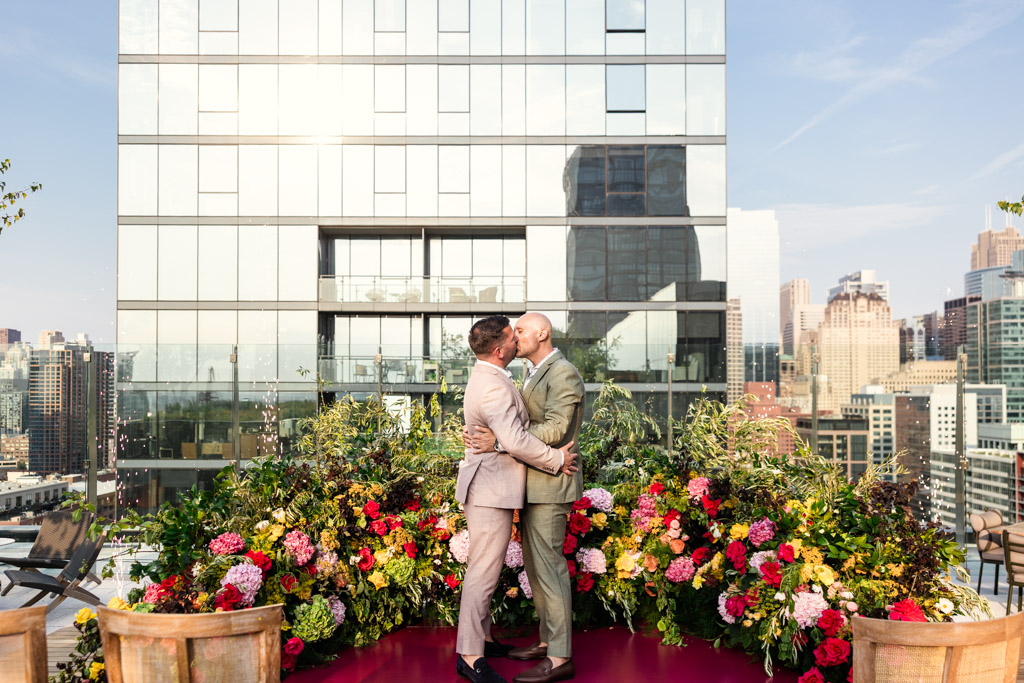 Newlyweds kiss during their Chicago rooftop wedding ceremony at 167 Events