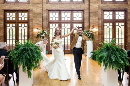 Bride and groom celebrate as they walk down the aisle after their Cafe Brauer wedding ceremony