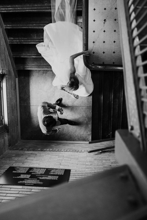 Black and white photo of bride and groom captured from above on stairs to the LondonHouse Cupola
