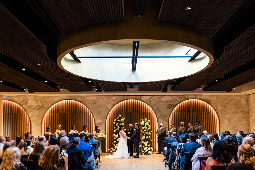 Couple exchanges vows as their guests gather around to witness Chicago Winery wedding ceremony