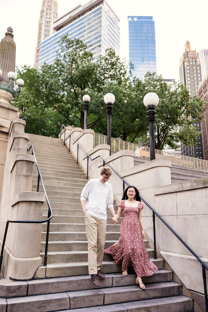 Couple walks down stairs near Chicago Riverwalk during sunrise engagement session