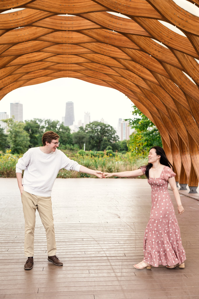 Couple dances under the Lincoln Park Honeycomb during Chicago sunrise engagement session