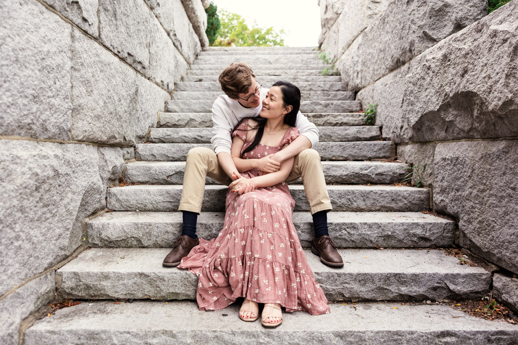 Couple sits on stone staircase at the Ulysses S. Grant Monument in Lincoln Park during sunrise Chicago engagement session