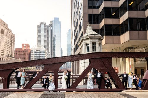 Fun wedding party photo on Monroe Street Bridge after summer wedding ceremony at South Branch Tavern and Grille