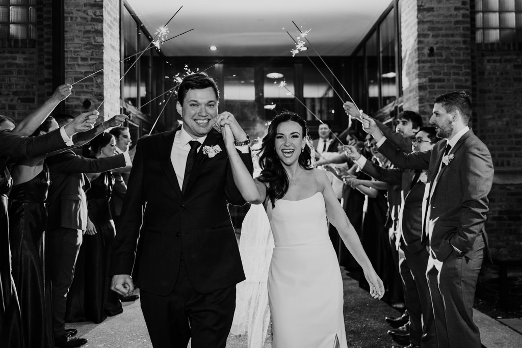 Joyful photo of just married bride and groom during their winter sparkler exit at Fairlie Chicago wedding venue