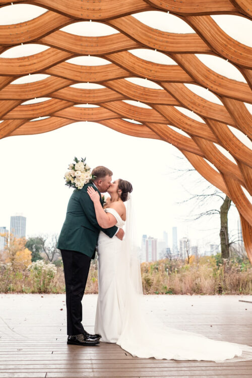 Bride and groom kiss under Lincoln park Honeycomb before Sarabande Chicago wedding