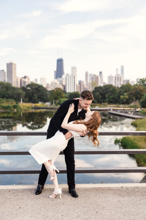Couple embraces in a romantic dip on a bridge in Lincoln Park during their downtown Chicago engagement session