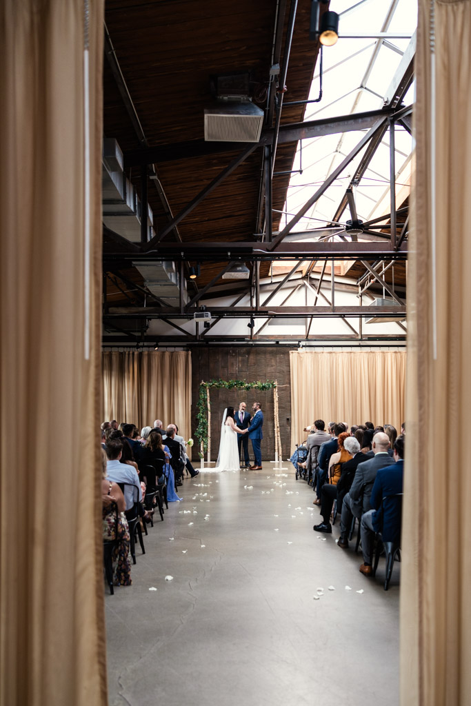 Bride and groom hold hands during their Ovation Chicago wedding ceremony