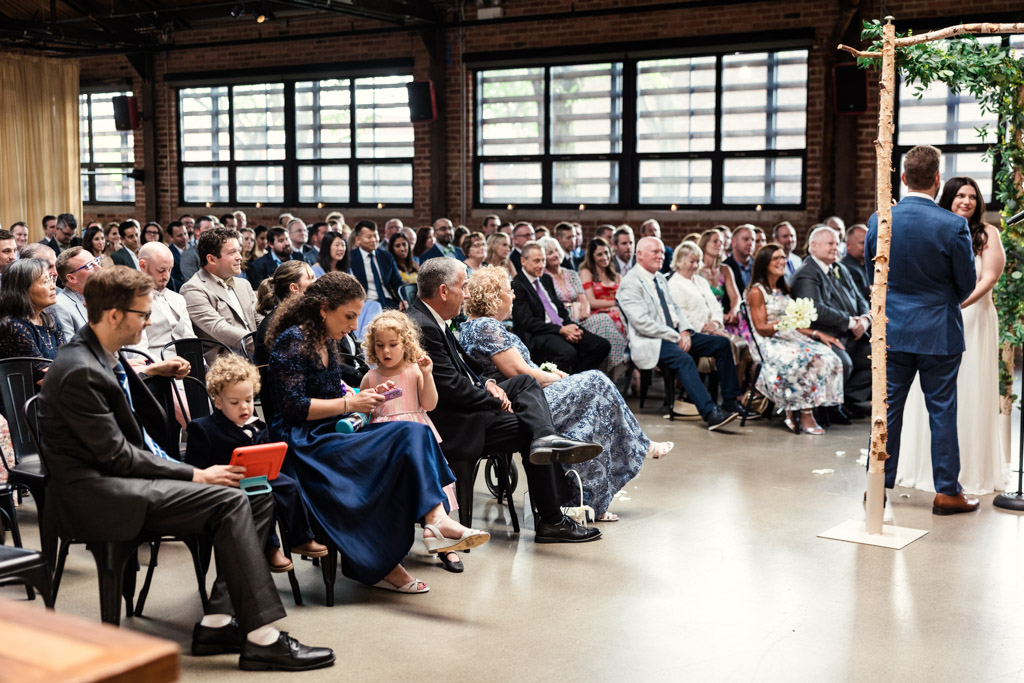 People seated indoors watching a wedding ceremony at Ovation Chicago