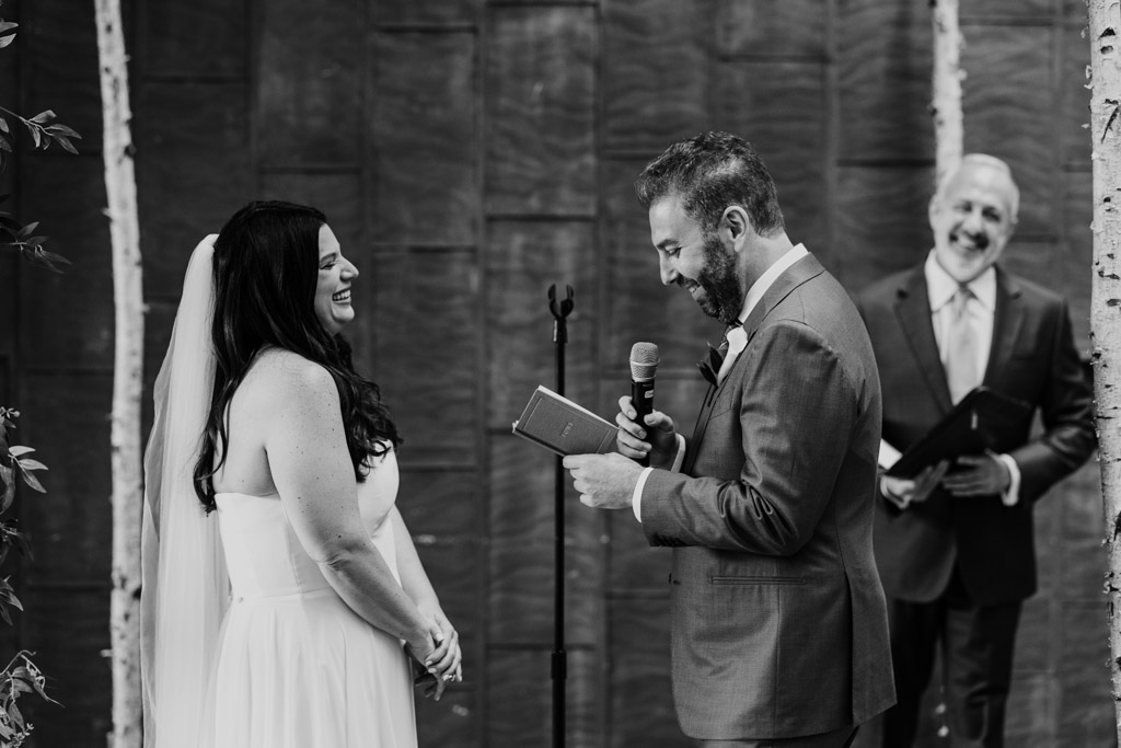 Black and white photo of groom reading vows to bride during their Ovation Chicago wedding ceremony