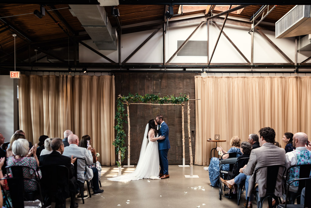 Bride and groom kiss during their wedding ceremony at Ovation Chicago
