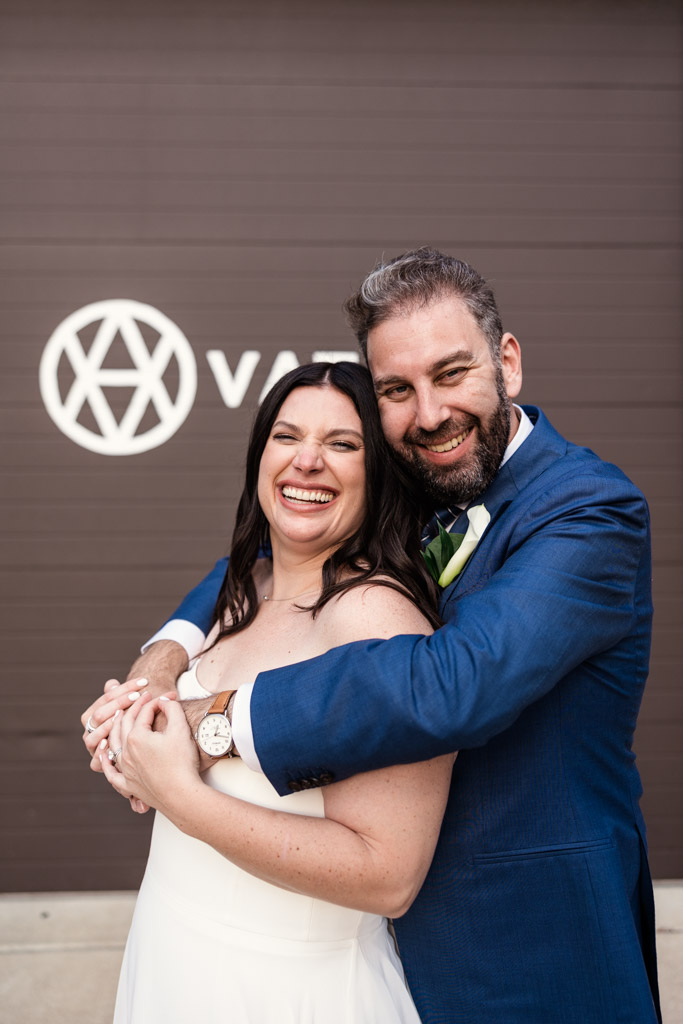 Portrait of happy bride and groom embracing and smiling in front Ovation Chicago wedding venue