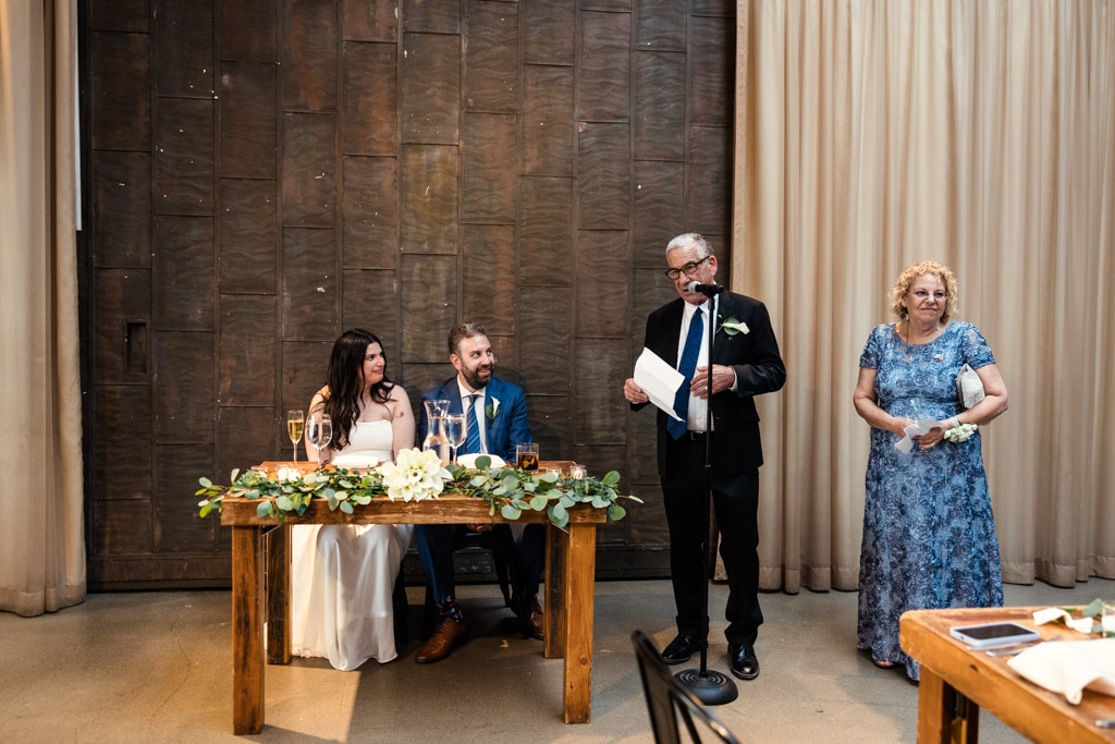 Father of the bride gives speech while newlyweds listen during Ovation Chicago wedding reception